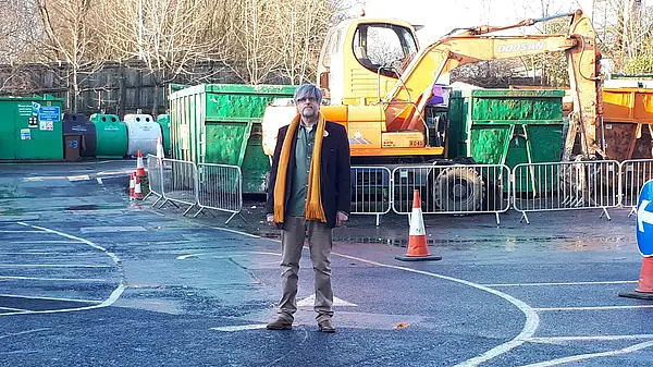 Volunteer in front of recycling centre