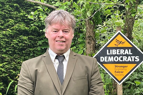 Paul Duffy standing beside a Liberal Democrat sign