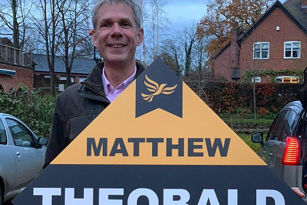 Matthew standing next to a Lib Dem sign